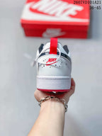 Rear view of the white sneaker showing the red heel pull tab, dark collar lining and red outsole edge.