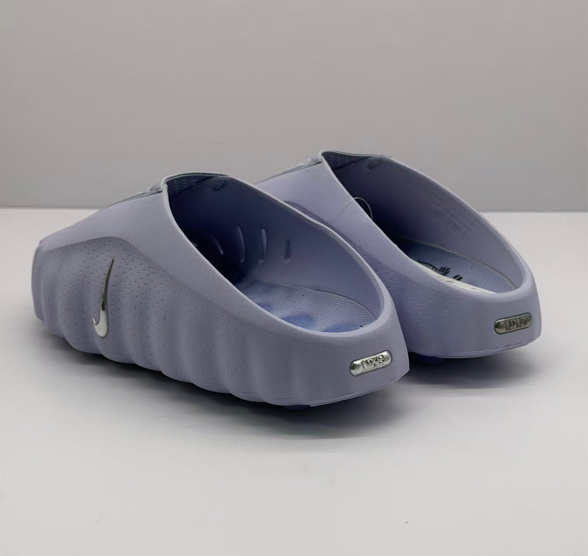 Rear view of the purple slides showing the open heel design and heel branding plaques.