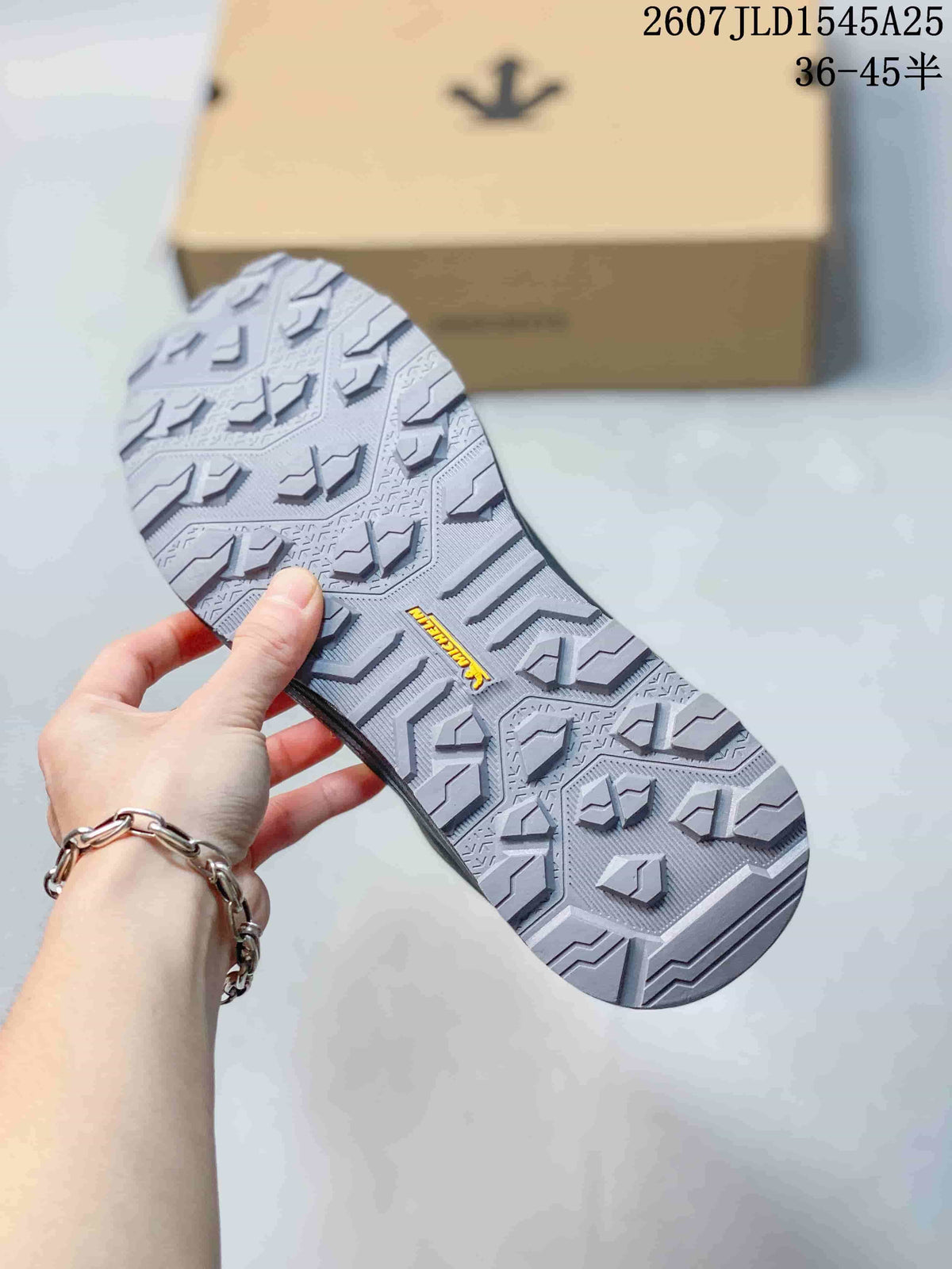 Close view of the sneaker outsole with a patterned tread and raised traction lugs.