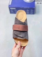 Top view of one clog showing the closed toe, dark gray upper, brown strap, and tan footbed.