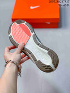 Close view of the sneaker outsole showing gray traction sections and a coral-colored forefoot area.