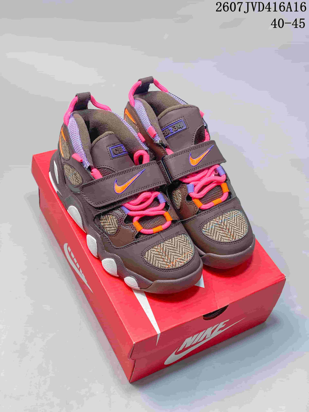 Pair of brown Nike sneakers with pink laces, colorful accents, forefoot straps, and a visible heel cushioning unit on a red Nike box; image text shows 2607JVD416A16 and 40–45.