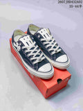 Pair of navy and white low-top Chuck Taylor-style sneakers with cross-shaped accents, shown on a red shoe box.