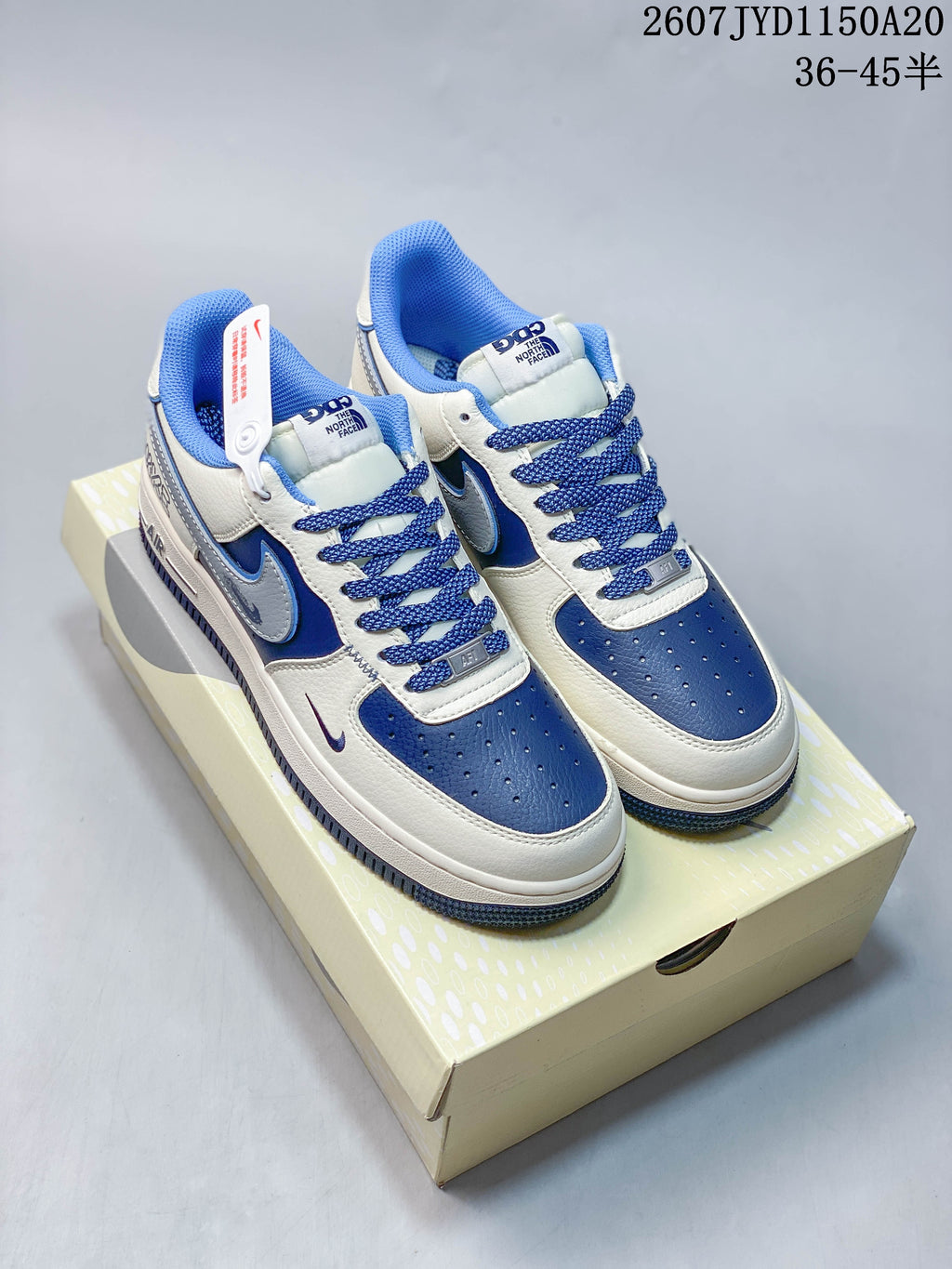 Pair of white and blue Nike low-top sneakers displayed on a shoe box.