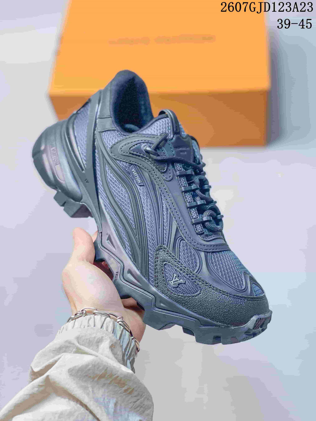 Close-up side view of a dark gray Louis Vuitton Summit sneaker showing layered panels, mesh sections, laces, and a rugged outsole.