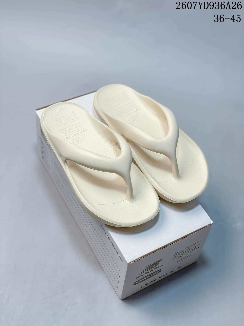 Pair of off-white New Balance flip-flop sandals displayed on a branded shoe box; image text shows product code 2607YD936A26 and size range 36–45.