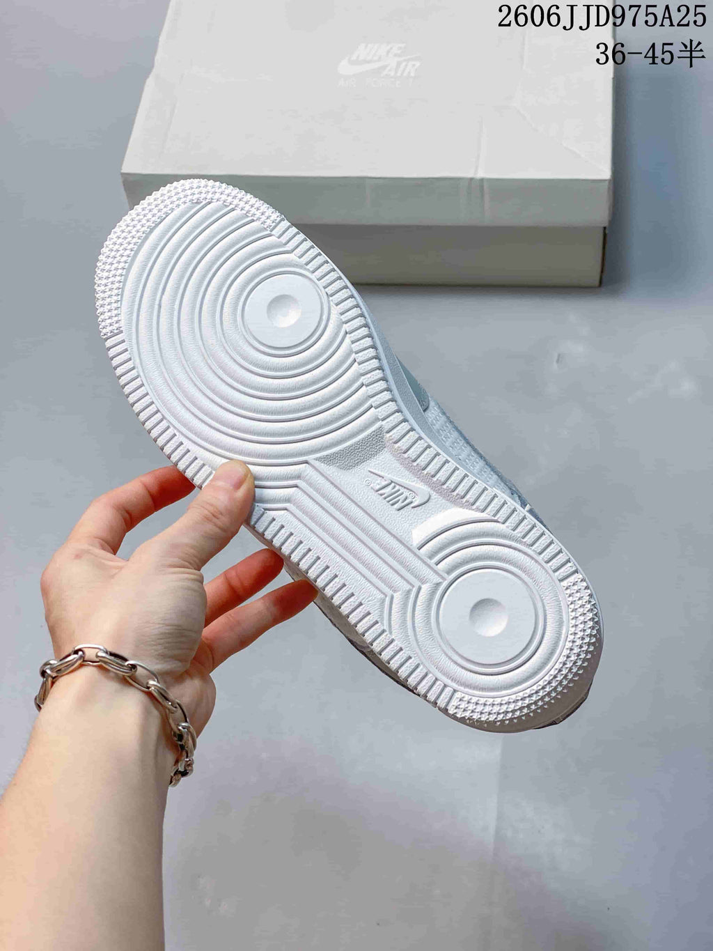 Bottom view of a Nike sneaker showing the white rubber outsole with circular traction patterns and Air branding.