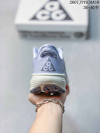 Rear view of a light lavender Nike ACG Pegasus Trail sneaker showing the ACG heel logo and layered cream midsole.
