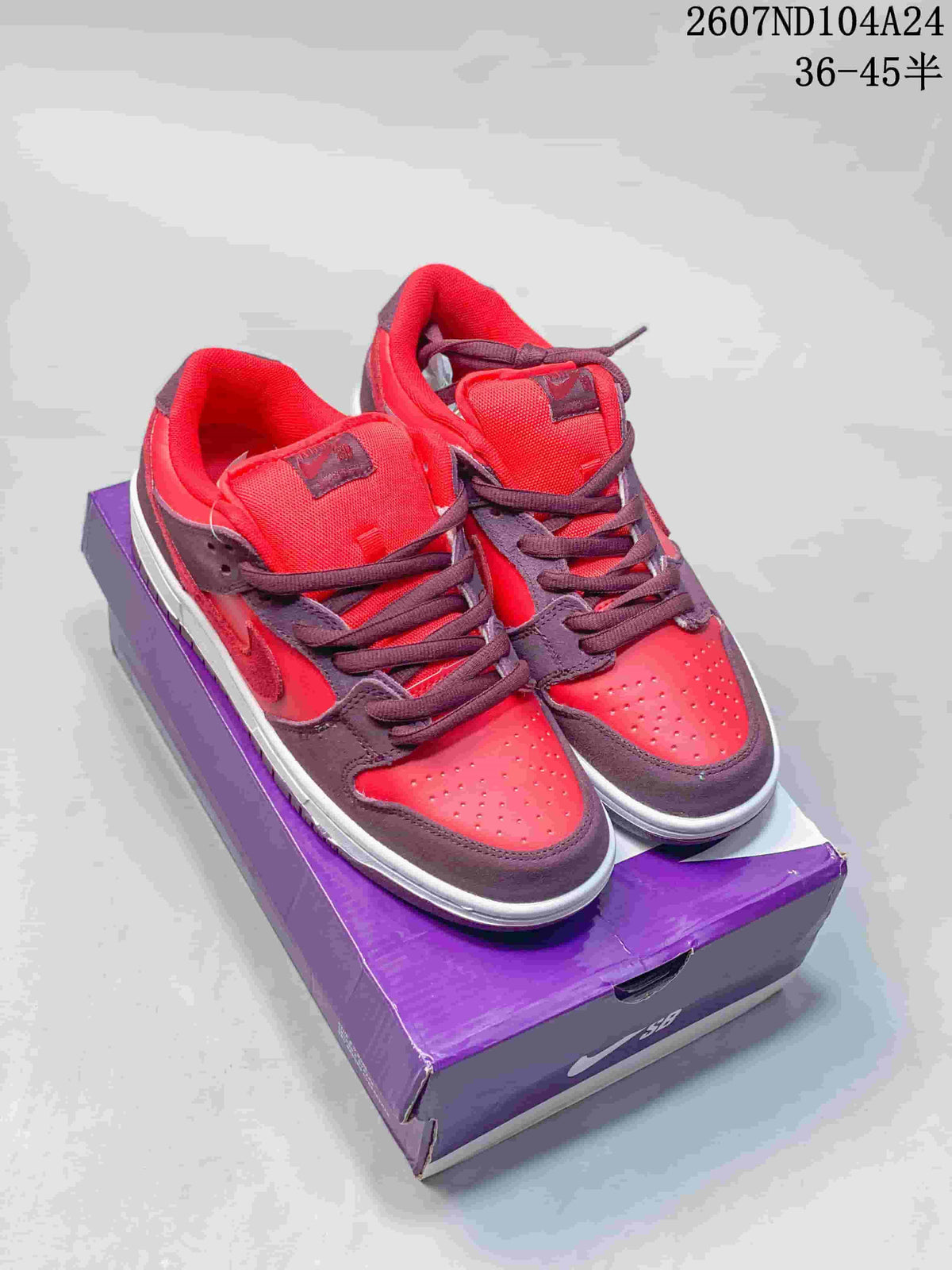 Red and dark brown Nike SB Dunk Low sneakers displayed on a purple shoebox.