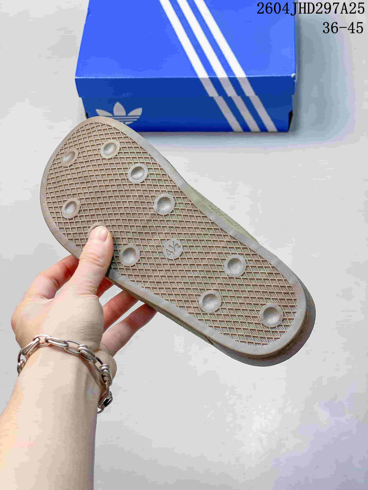 Textured outsole of a green mule with a blue box in the background