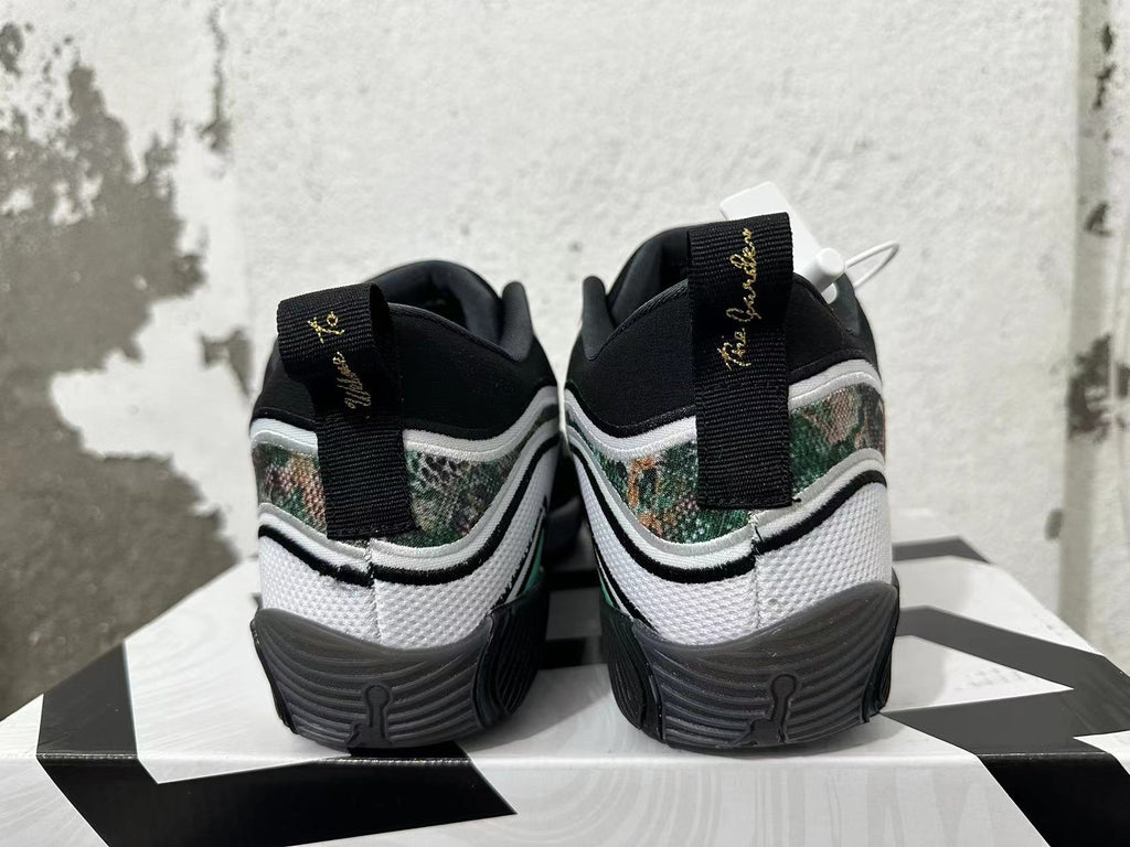 Rear view of white and black Jordan sneakers with camouflage-patterned panels and gold heel embroidery