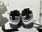Rear view of white and black Jordan sneakers with camouflage-patterned panels and gold heel embroidery