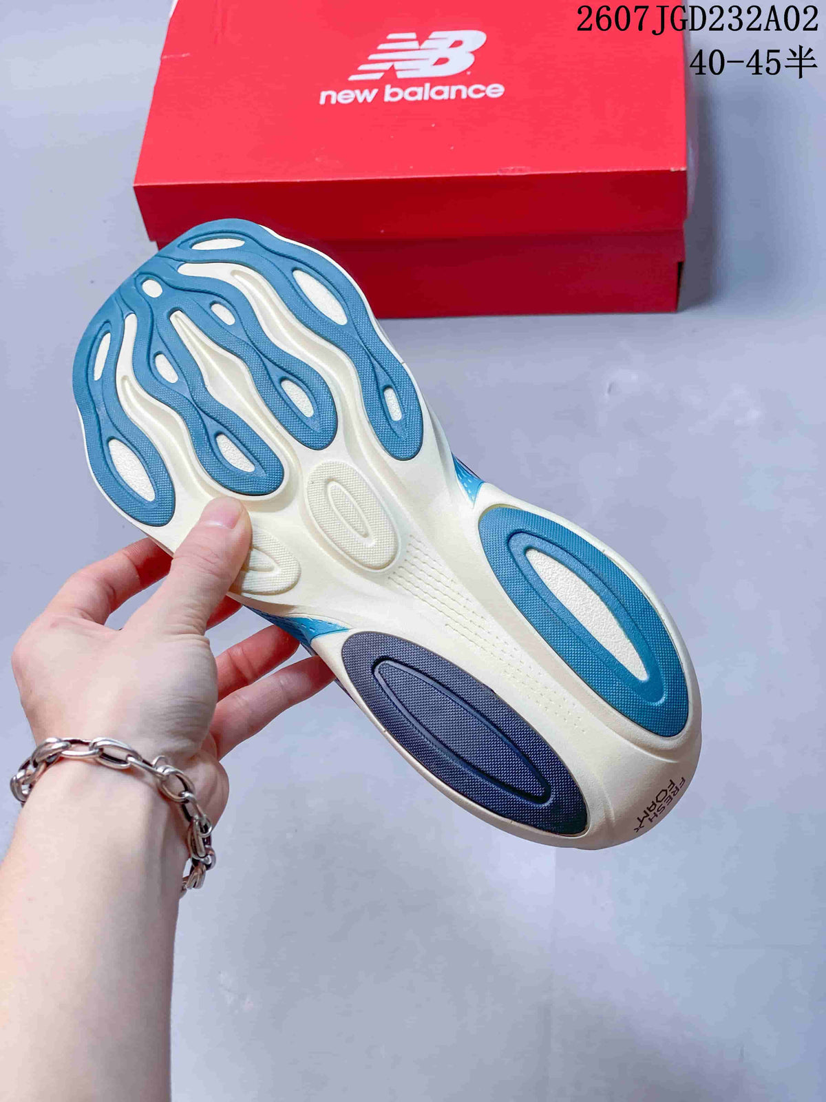 Underside of a blue and light-colored running shoe showing the outsole pattern