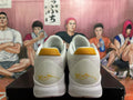 Rear view of white Nike basketball shoes with gold-colored heel accents.