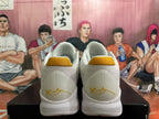 Rear view of white Nike basketball shoes with gold-colored heel accents.
