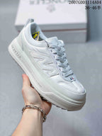 Angled side view of the white sneaker showing Moncler branding on the sidewall, layered construction and raised sole.