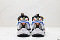 Rear view of the white, blue, black, and yellow sneakers showing layered heel panels and textured black outsoles.