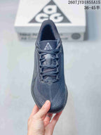Top view of a dark gray Nike ACG Pegasus Trail sneaker showing the mesh-like tongue, laces, and perforated toe area.