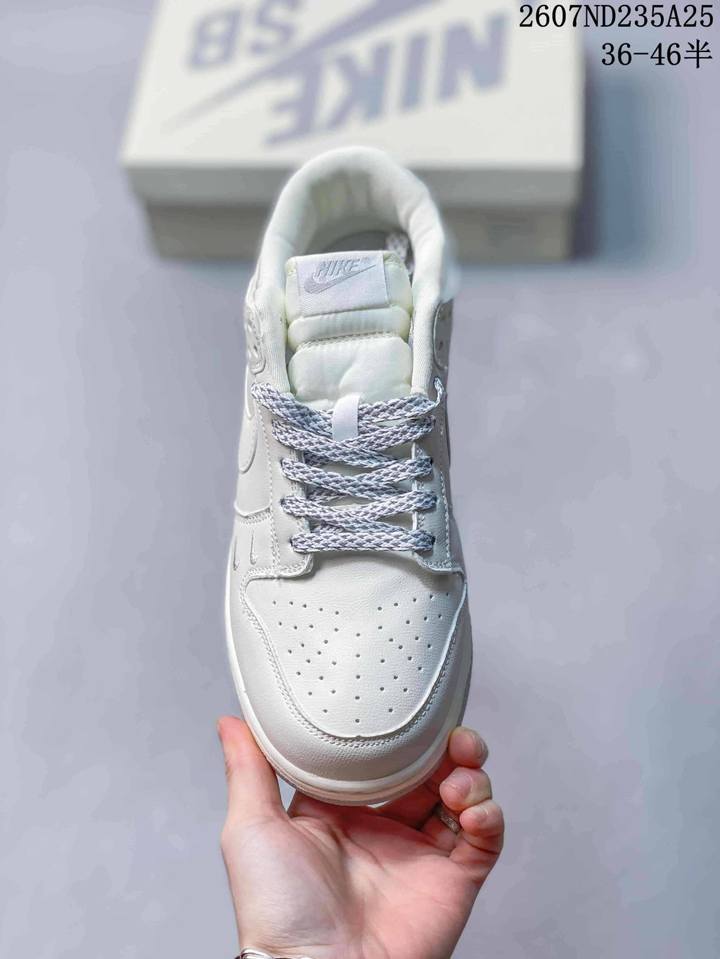 Top view of the white sneaker showing the perforated toe box, padded tongue and woven laces.