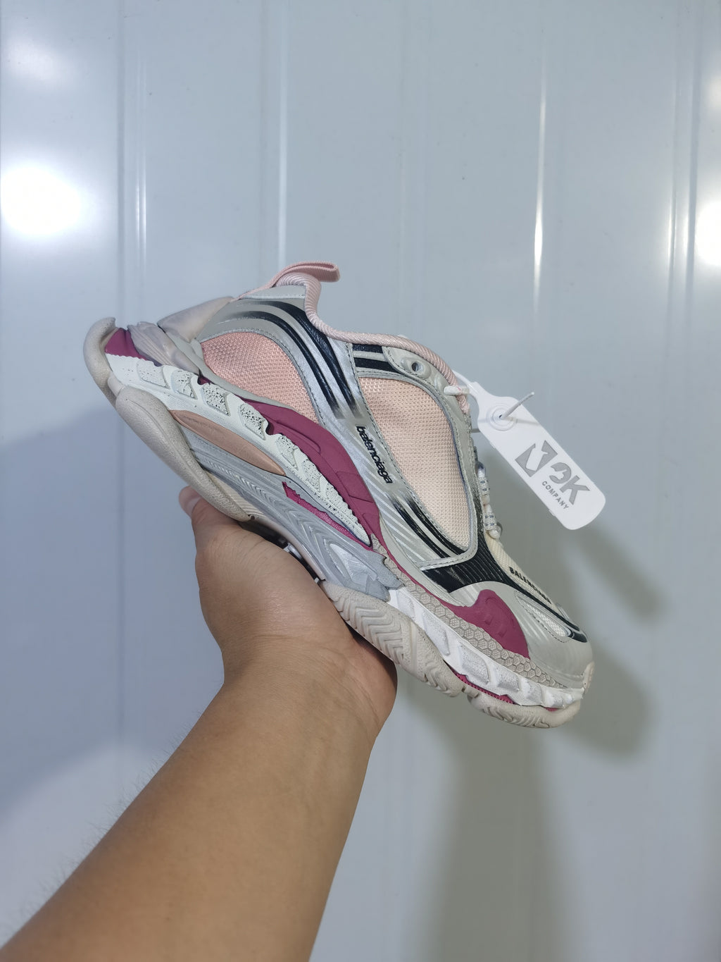 Close-up view of a Balenciaga Triple S 2 6800 sneaker showing cream, pink, black and gray layered detailing.