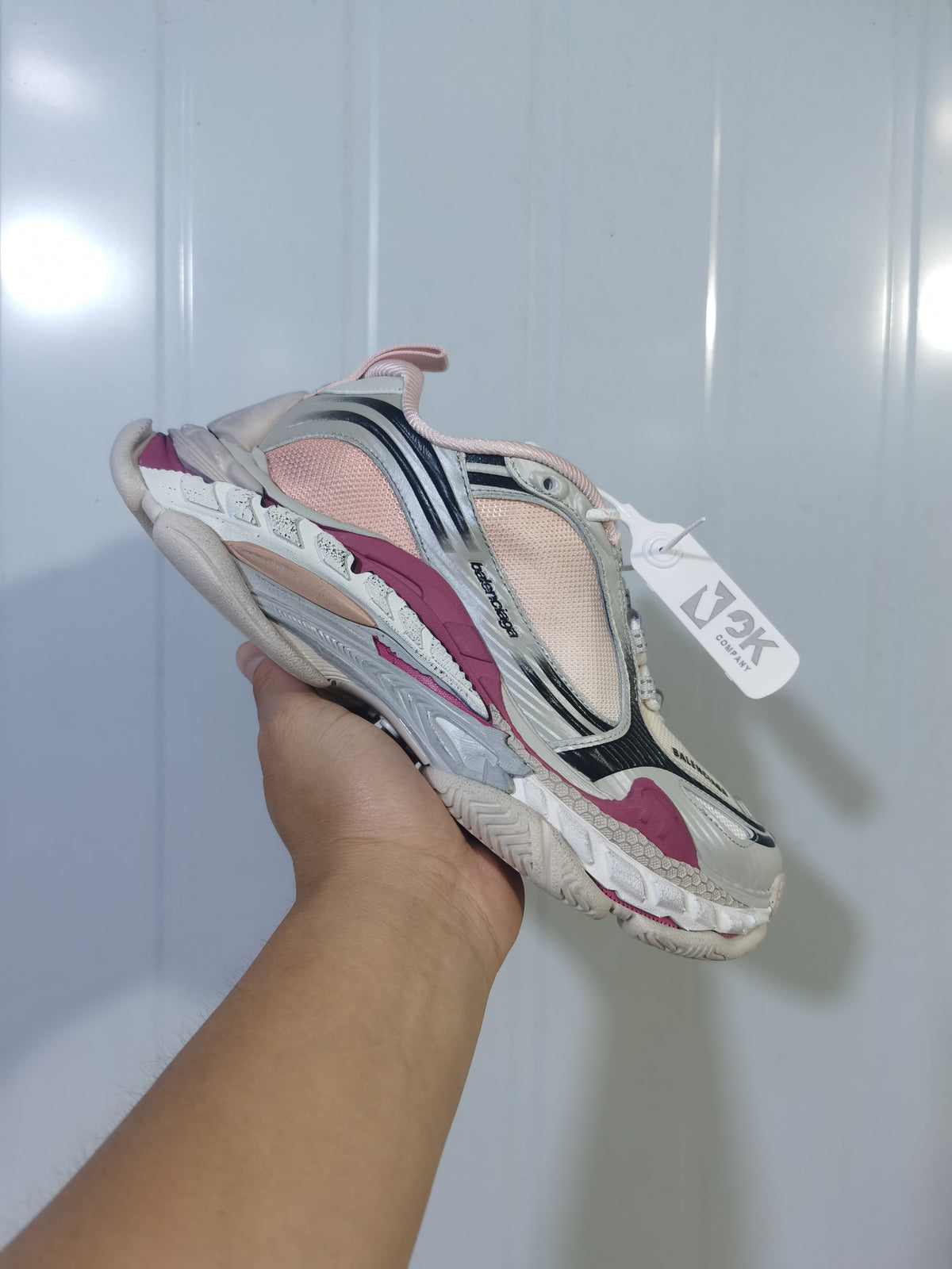 Close-up view of a Balenciaga Triple S 2 6800 sneaker showing cream, pink, black and gray layered detailing.