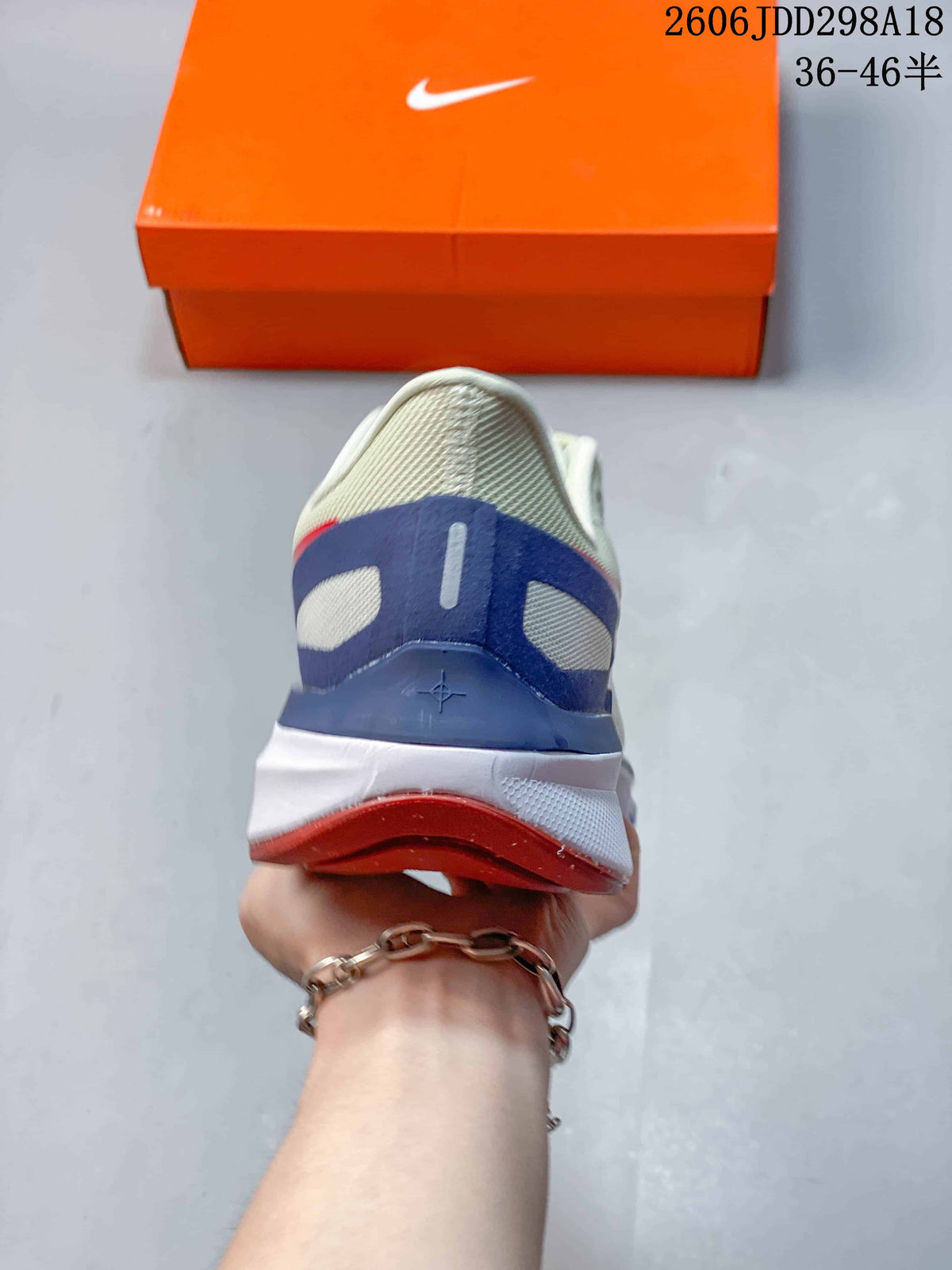 Rear view of the white sneaker showing the blue heel structure, red accent strip, and outsole.