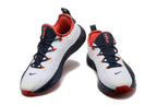 Pair of white, navy, red, and gold Nike LeBron training shoes shown from the front