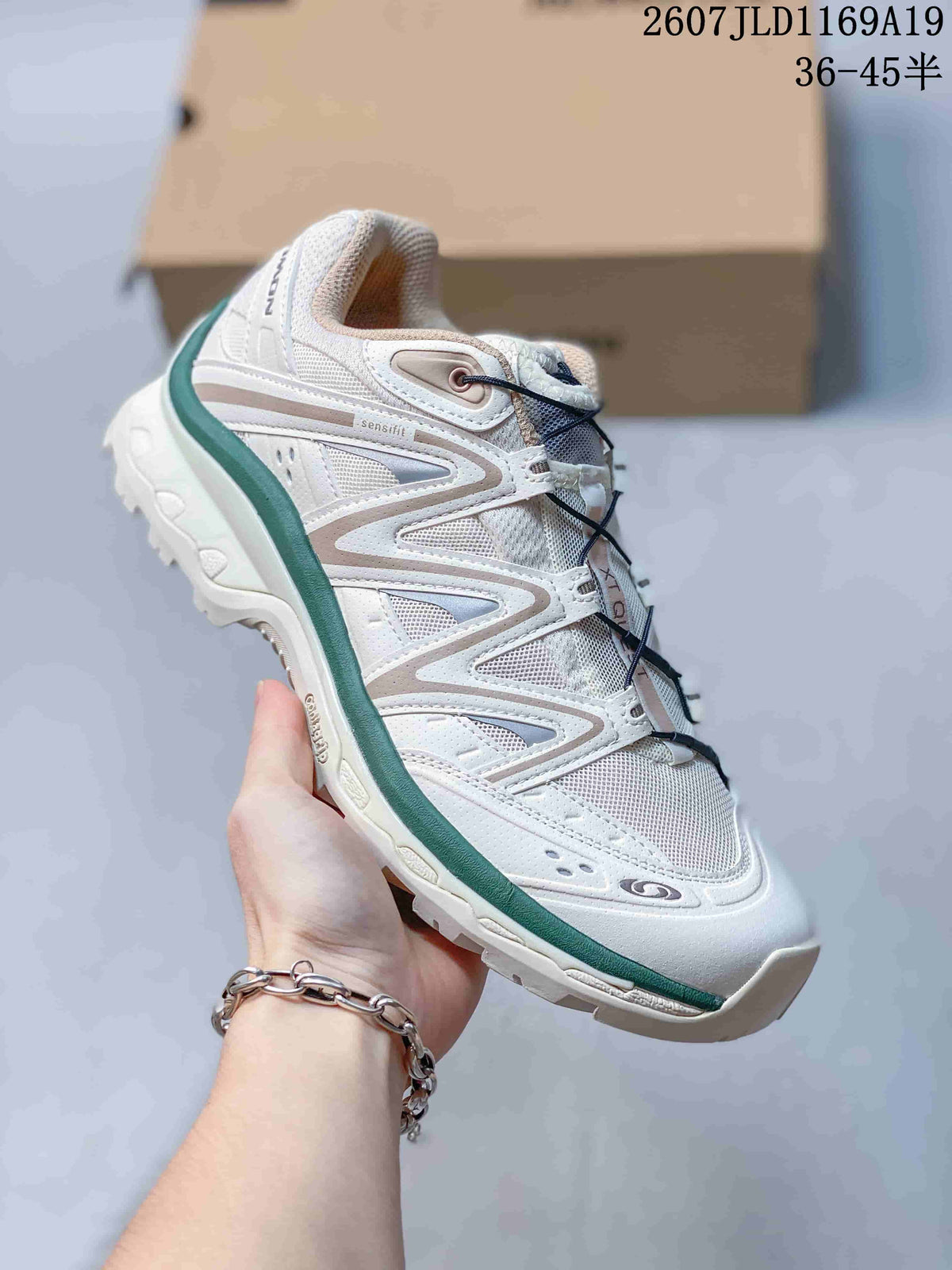 Side view of a white Salomon XT-Quest sneaker with green trim, layered panels, dark laces and a textured outsole.