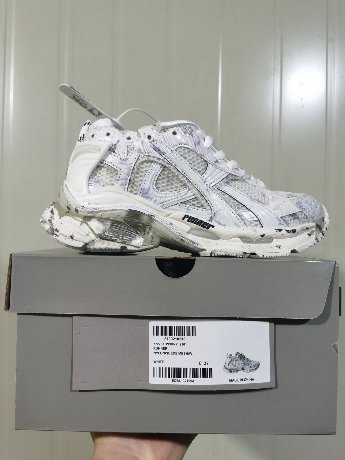 Side view of the sneaker and box; the label shows white color, style text, size marking C 37, and Made in China text.