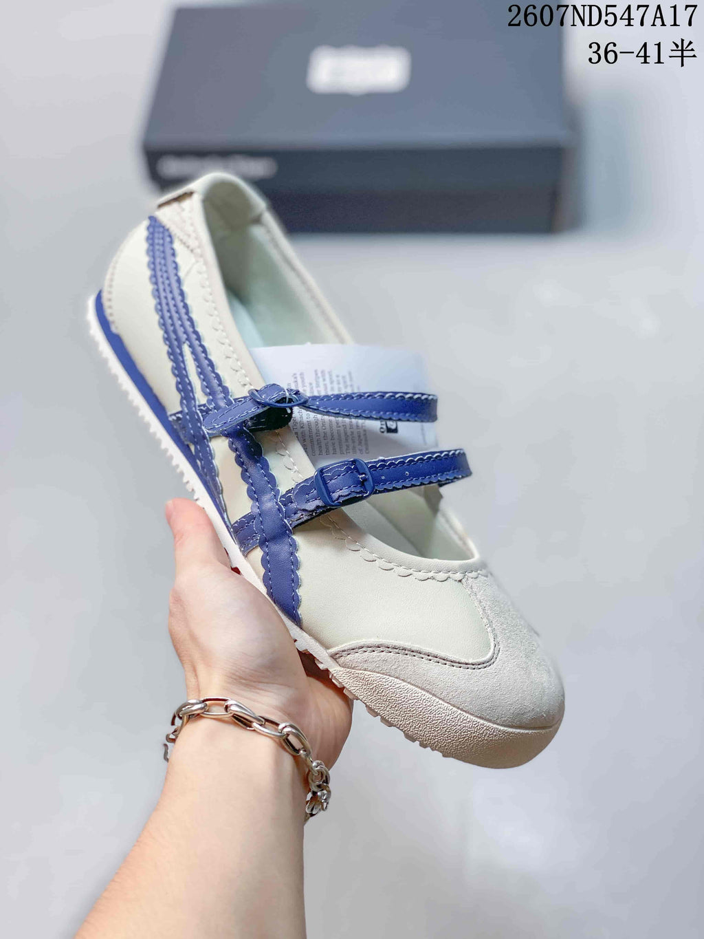 White Mary Jane sneaker with contrasting blue side stripes and blue buckle straps.