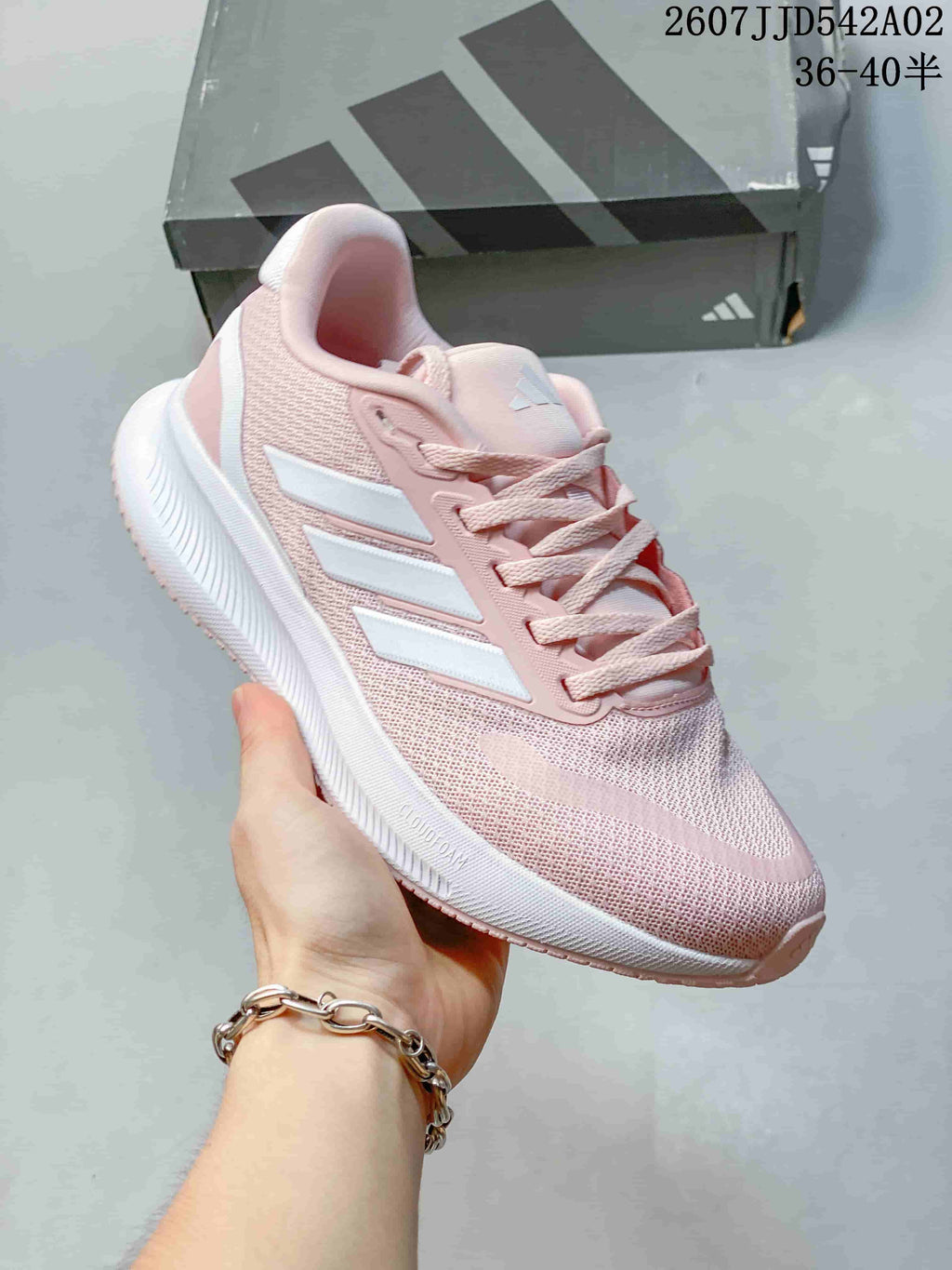 Angled side view of the pink running shoe with white stripes.