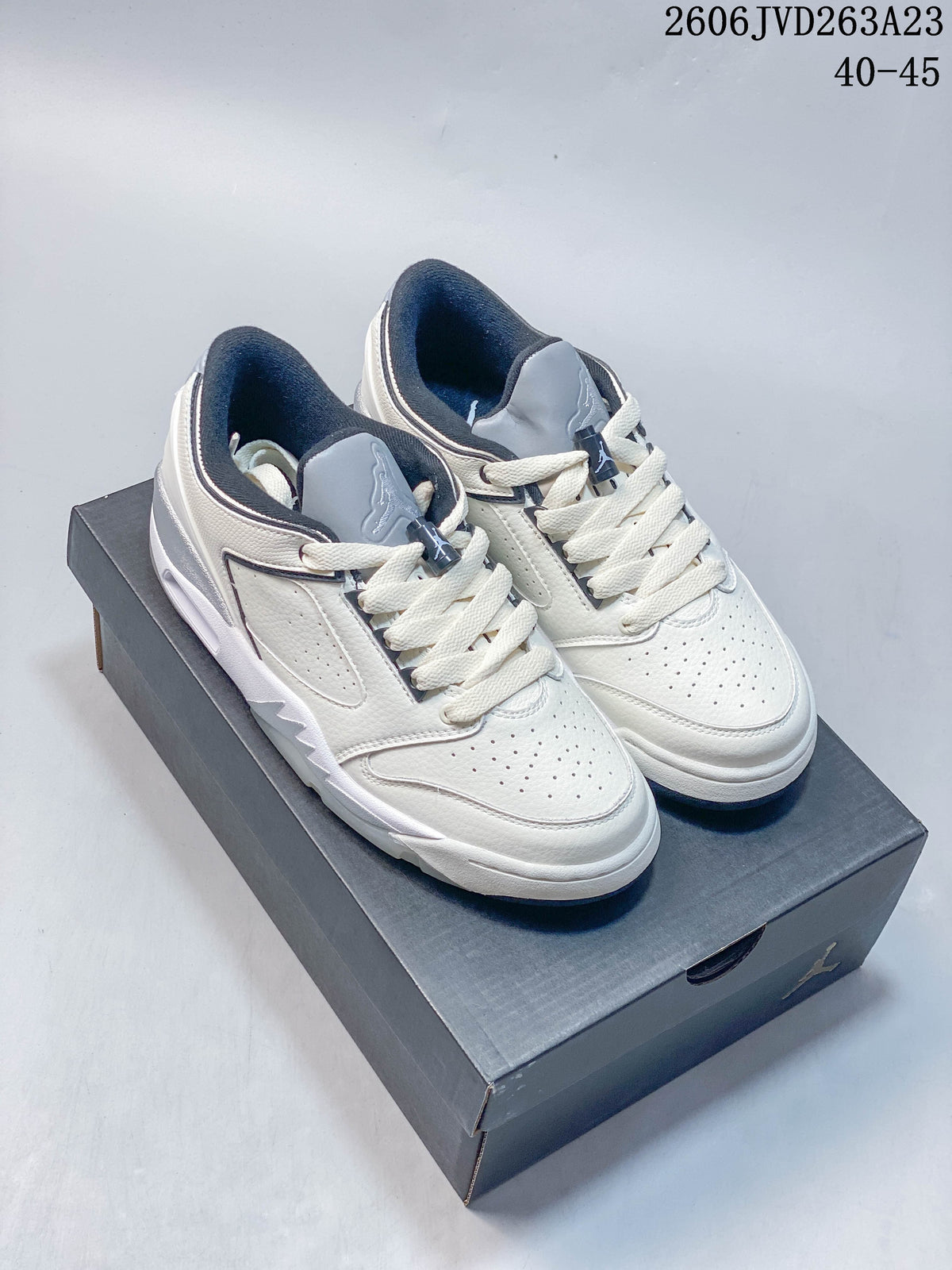 Pair of white Jordan Sixty Plus Low shoes with gray and navy accents, shown on a shoe box.
