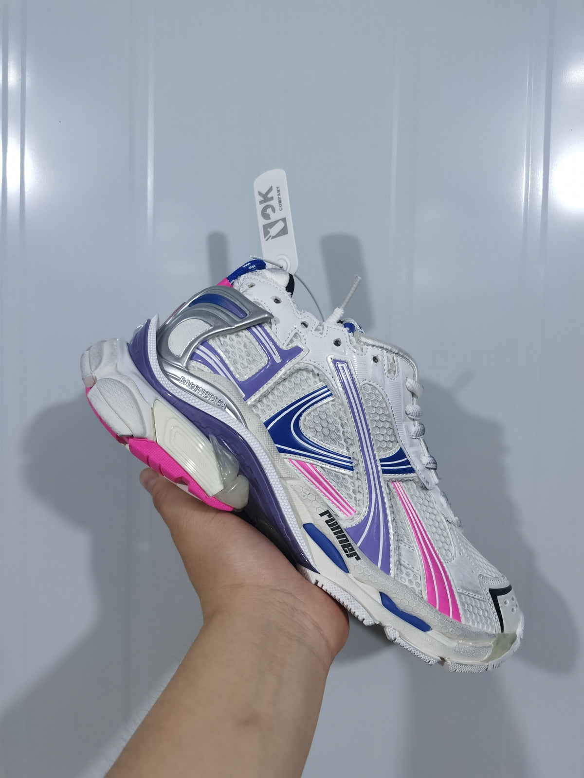 Close angled view of the white Balenciaga 6120 runner sneaker showing layered side panels and a chunky sole.