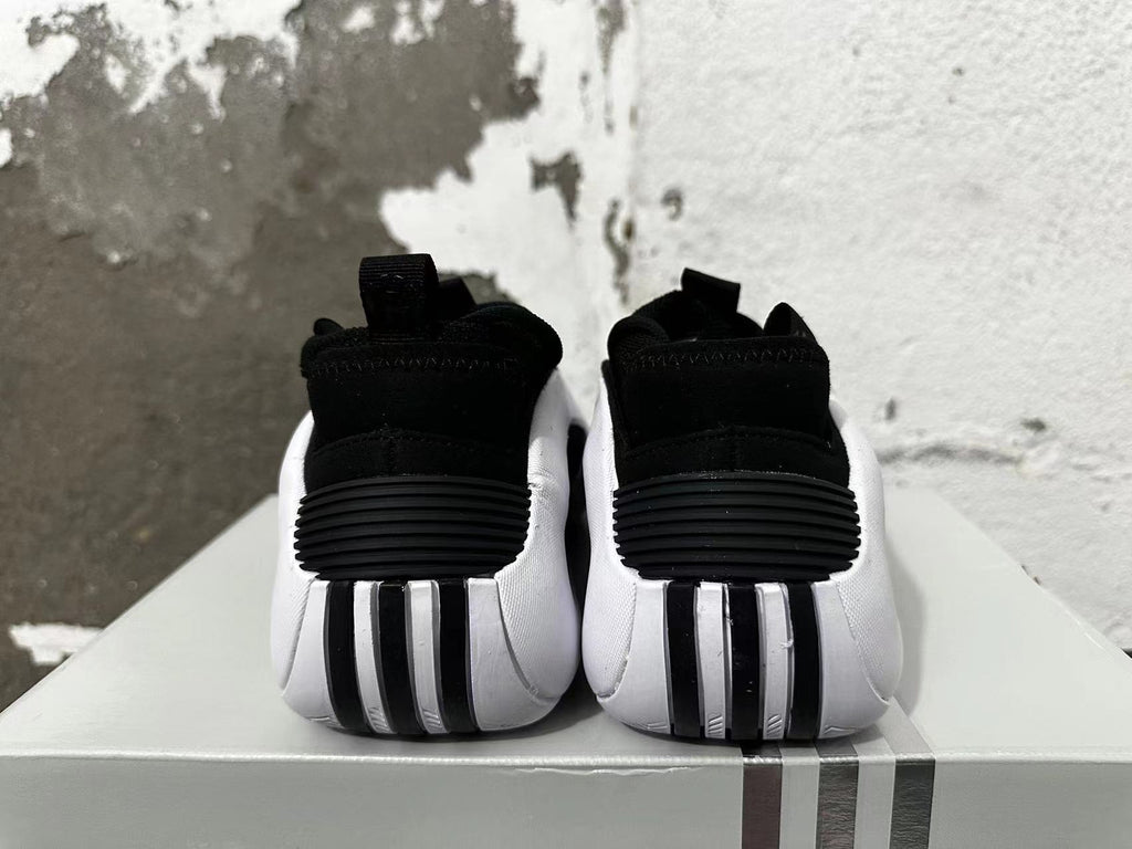 Rear view of black and white Adidas basketball shoes showing ridged heel details.