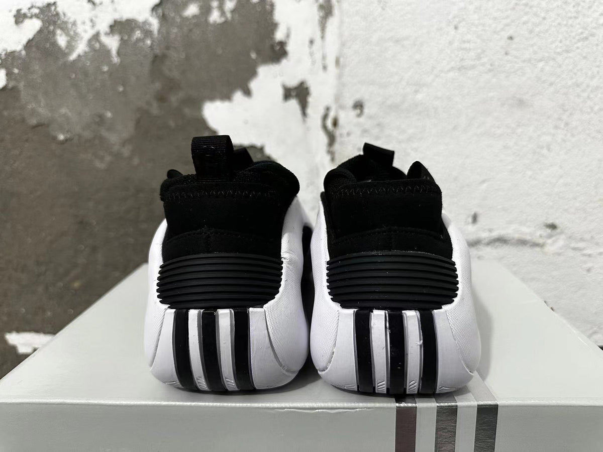 Rear view of black and white Adidas basketball shoes showing ridged heel details.