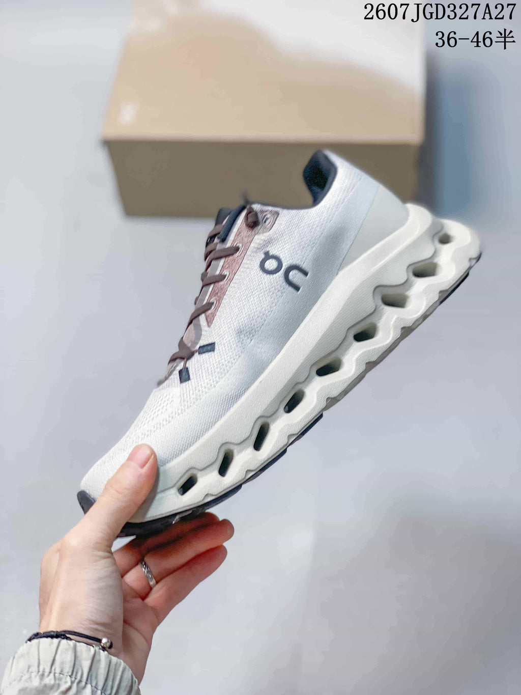 Side profile of the white and gray sneaker showing the layered upper and segmented midsole.