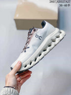 Side profile of the white and gray sneaker showing the layered upper and segmented midsole.