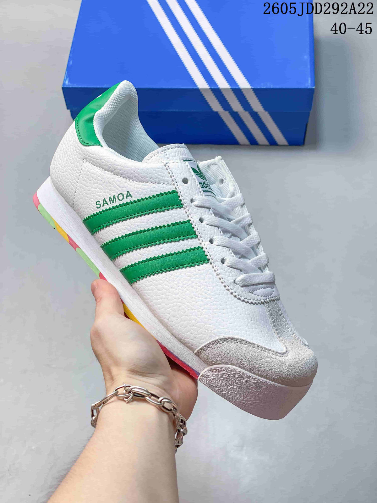 White Adidas Samoa sneaker with green side stripes and multicolor sole accents.