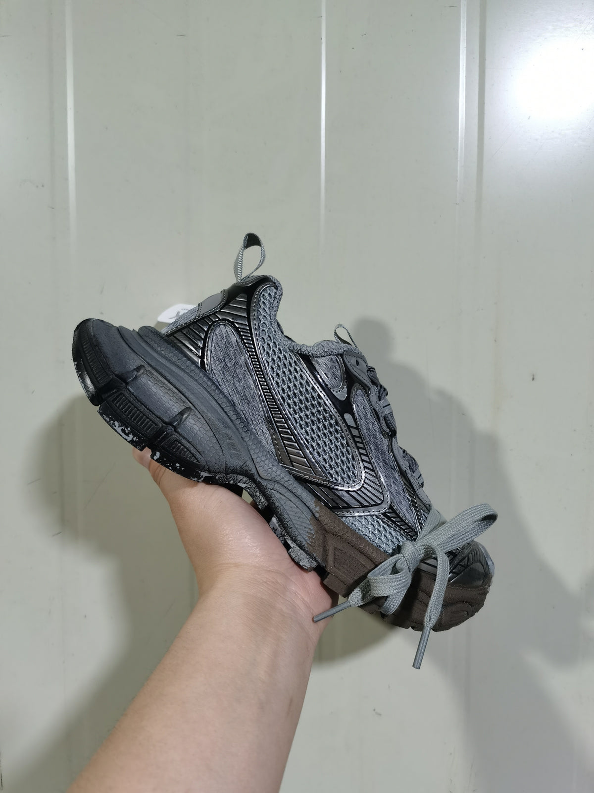 Angled view of the sneaker highlighting the mesh panels, sculpted side detailing, and segmented sole.