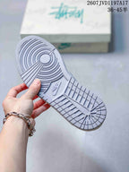 Close view of the grey textured rubber outsole with circular and segmented tread patterns.