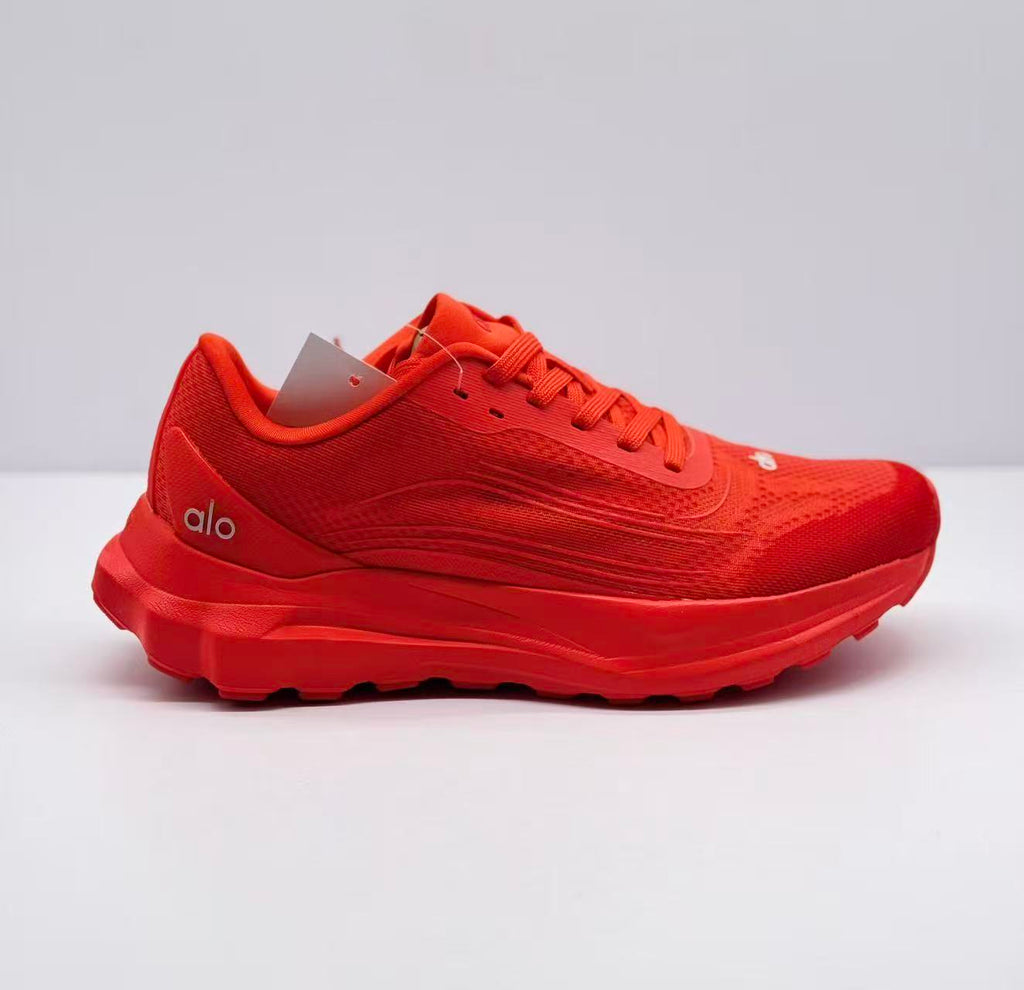 Side view of a red alo sneaker showing the textured upper, lace fastening, layered midsole, and heel logo.