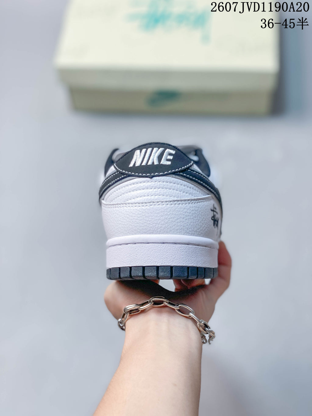 Rear view of the white sneaker showing the black padded collar, NIKE heel branding, and dark outsole edge.
