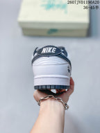 Rear view of the white sneaker showing the black padded collar, NIKE heel branding, and dark outsole edge.
