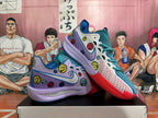 Angled view of the pair of Nike basketball sneakers, highlighting the colorful smiley-face graphics, Swoosh, and layered sole.