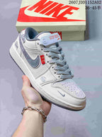 Close-up of a light-colored low-top sneaker with gray overlays, contrast swoosh, and red accent tab.