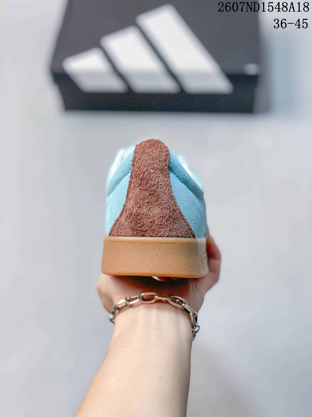 Rear view showing the light blue heel, brown heel panel, and gum-colored outsole.
