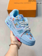 Angled side view of the light blue Louis Vuitton Trainer sneaker showing patterned panels, white laces, pink accents, and the low-top silhouette.