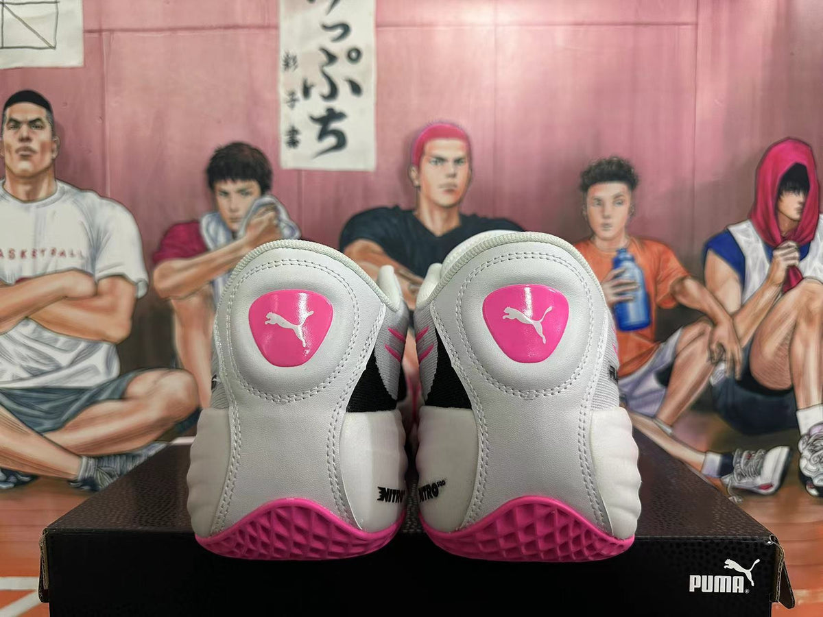 Heel view of white PUMA All-Pro shoes with pink heel details and outsole.