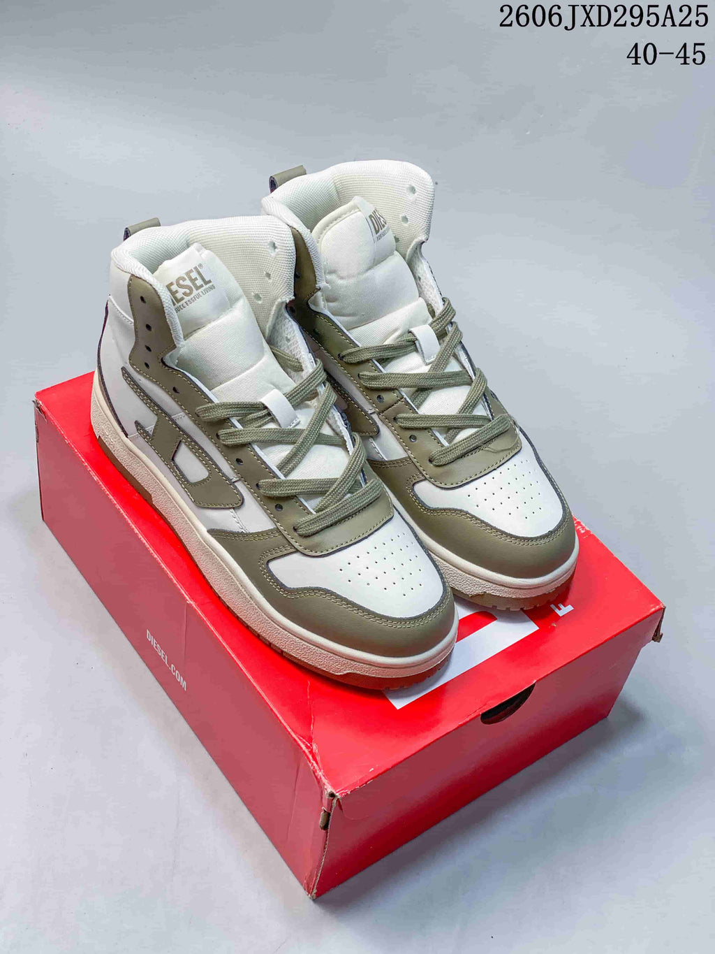 Pair of white and khaki Diesel S-Ukiyo high-top lace-up sneakers on a red box