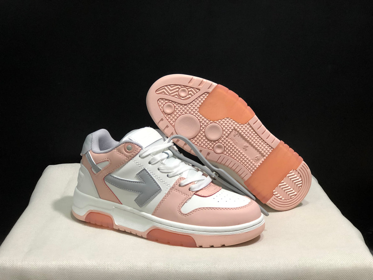 Angled view of one sneaker with the outsole lifted to show the patterned pink rubber tread.